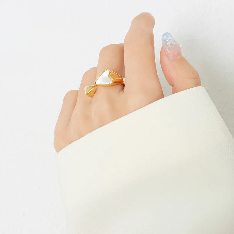 Gold ring on a finger against a white background