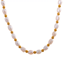 Pearl necklace with gold beads on a white background.