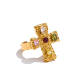 Gold cross-shaped ring with embedded gemstones on a white background