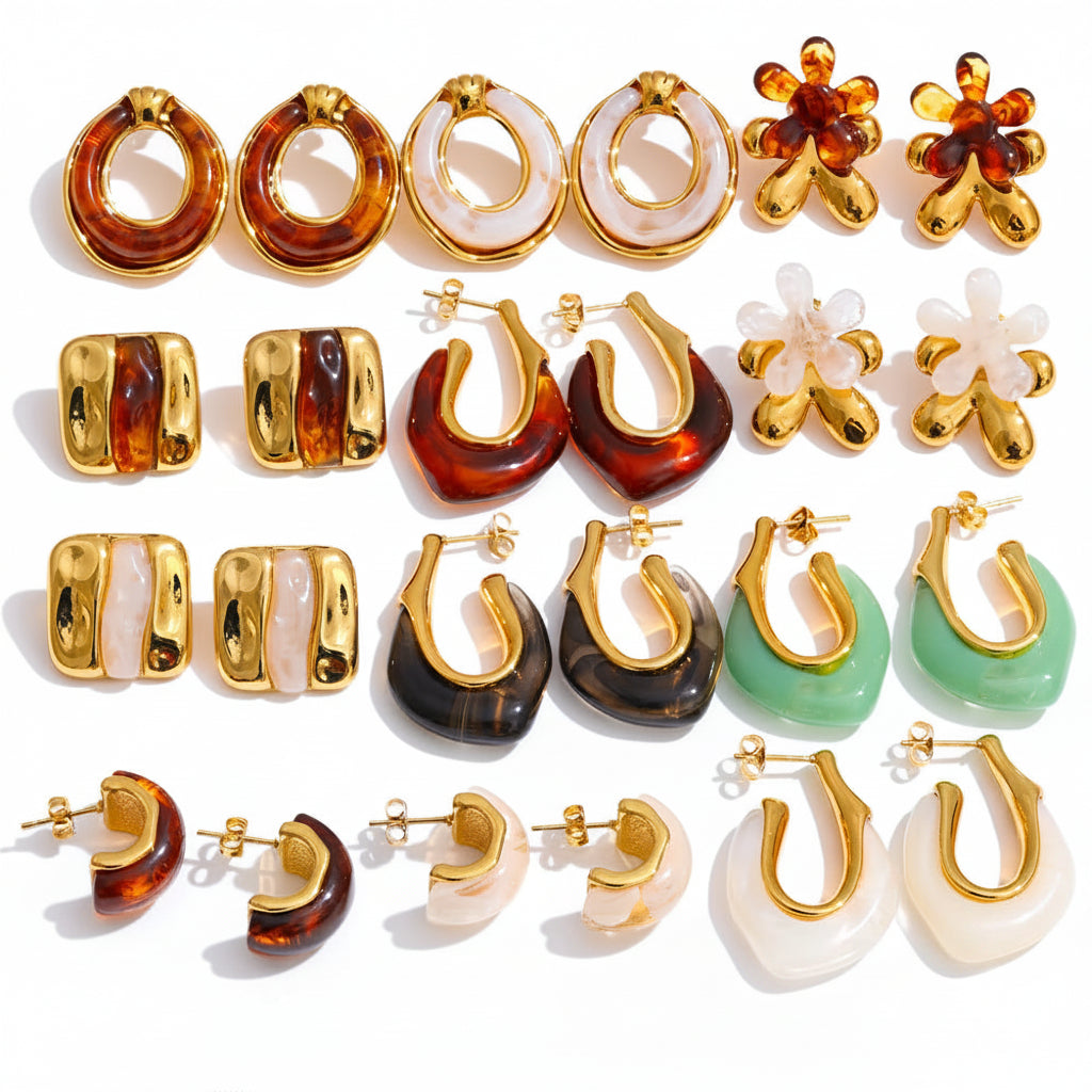Collection of gold and colored hoop earrings on a white background 