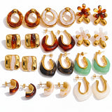 Collection of gold and colored hoop earrings on a white background 