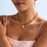 Woman wearing a gold chain necklace with a star pendant against a light blue background