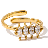 Gold ring with marquise-shaped gemstones on a white background
