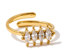 Gold ring with marquise-shaped gemstones on a white background