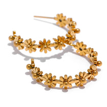 Gold floral hoop earrings on a white background