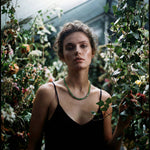 Woman in a greenhouse holding a leafy plant