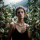 Woman in a greenhouse holding a leafy plant
