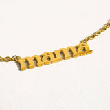 Gold necklace with 'mama' pendant on a white background