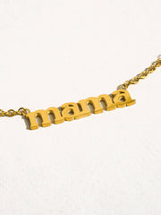 Gold necklace with 'mama' pendant on a white background