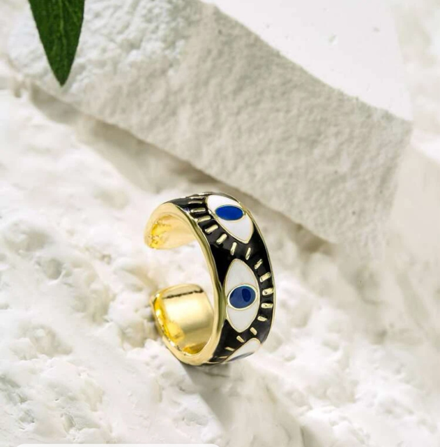 Adjustable evil eye ring with black enamel, gold plating, and blue accents, designed for everyday wear and believed to ward off negative energy.