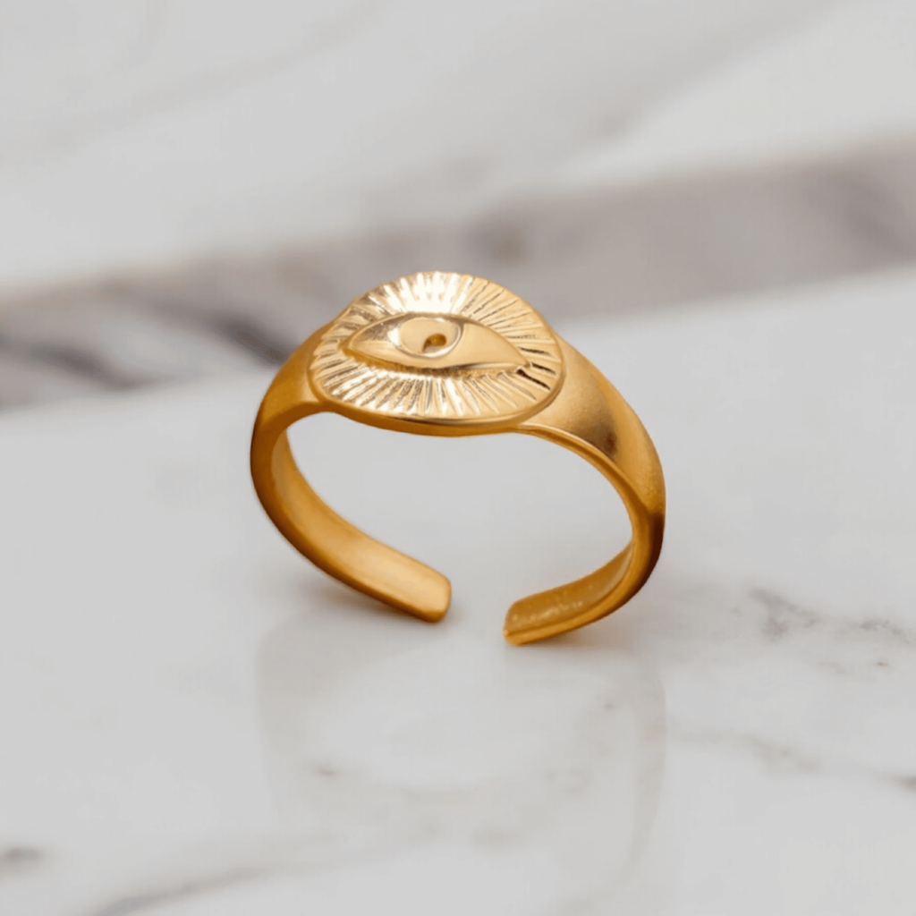 Protect yourself in style with this adjustable Gold Evil Eye Ring, made from stainless steel and 18k gold plating. Features an evil eye engraving for added protection.