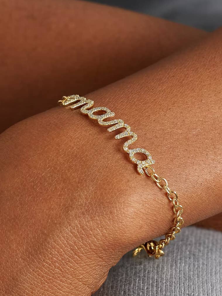 Gold bracelet with 'mama' charm on a wrist