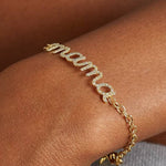 Gold bracelet with 'mama' charm on a wrist