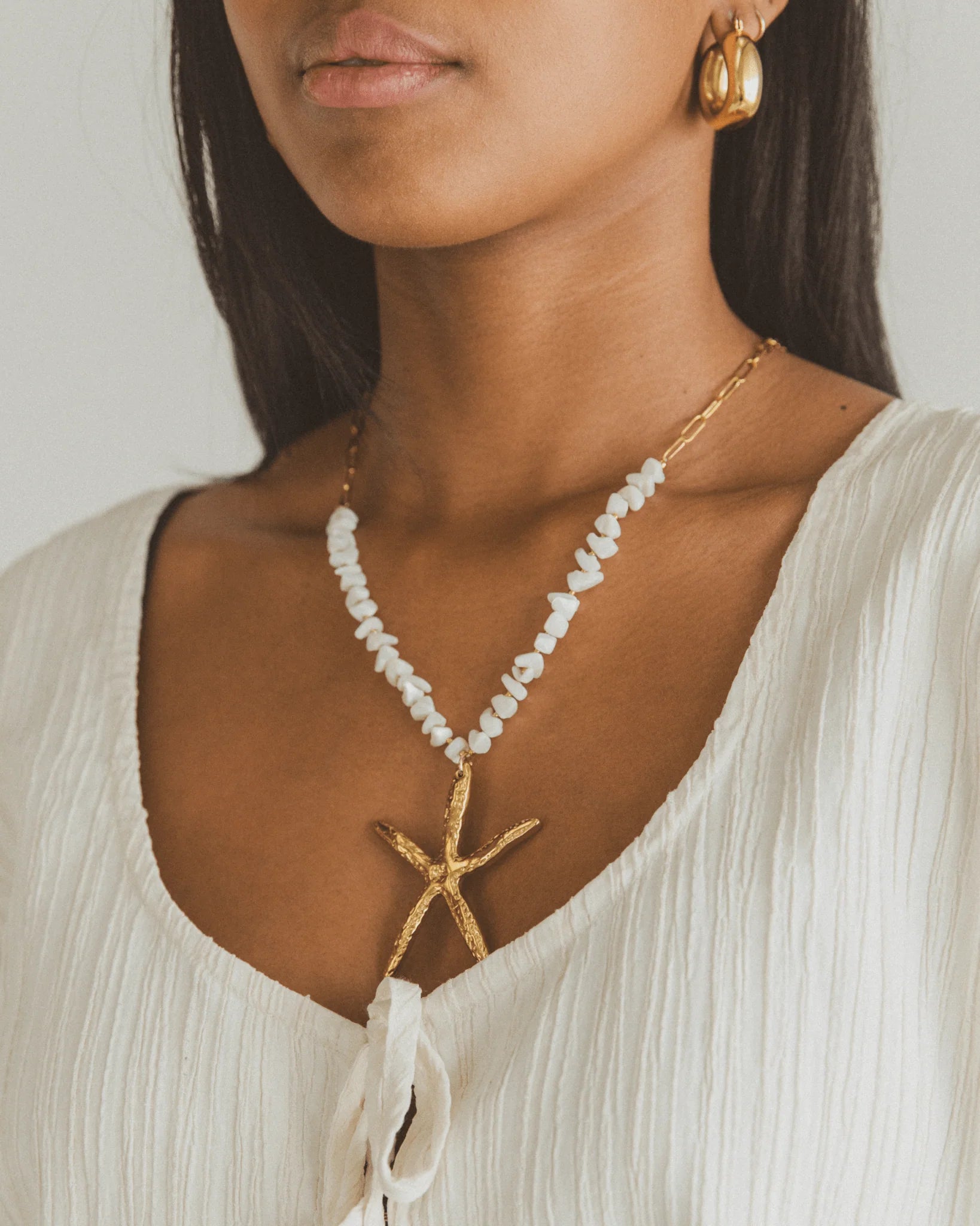 Beach-inspired golden starfish necklace with natural shell bead chain and gold plating, perfect for summer or coastal outfits