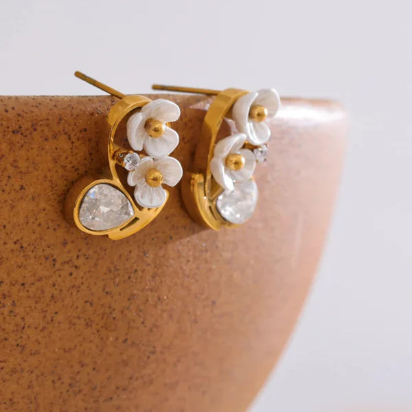 Elegant cherry blossom stud earrings with gold plating and white petals, accented by sparkling cubic zirconia