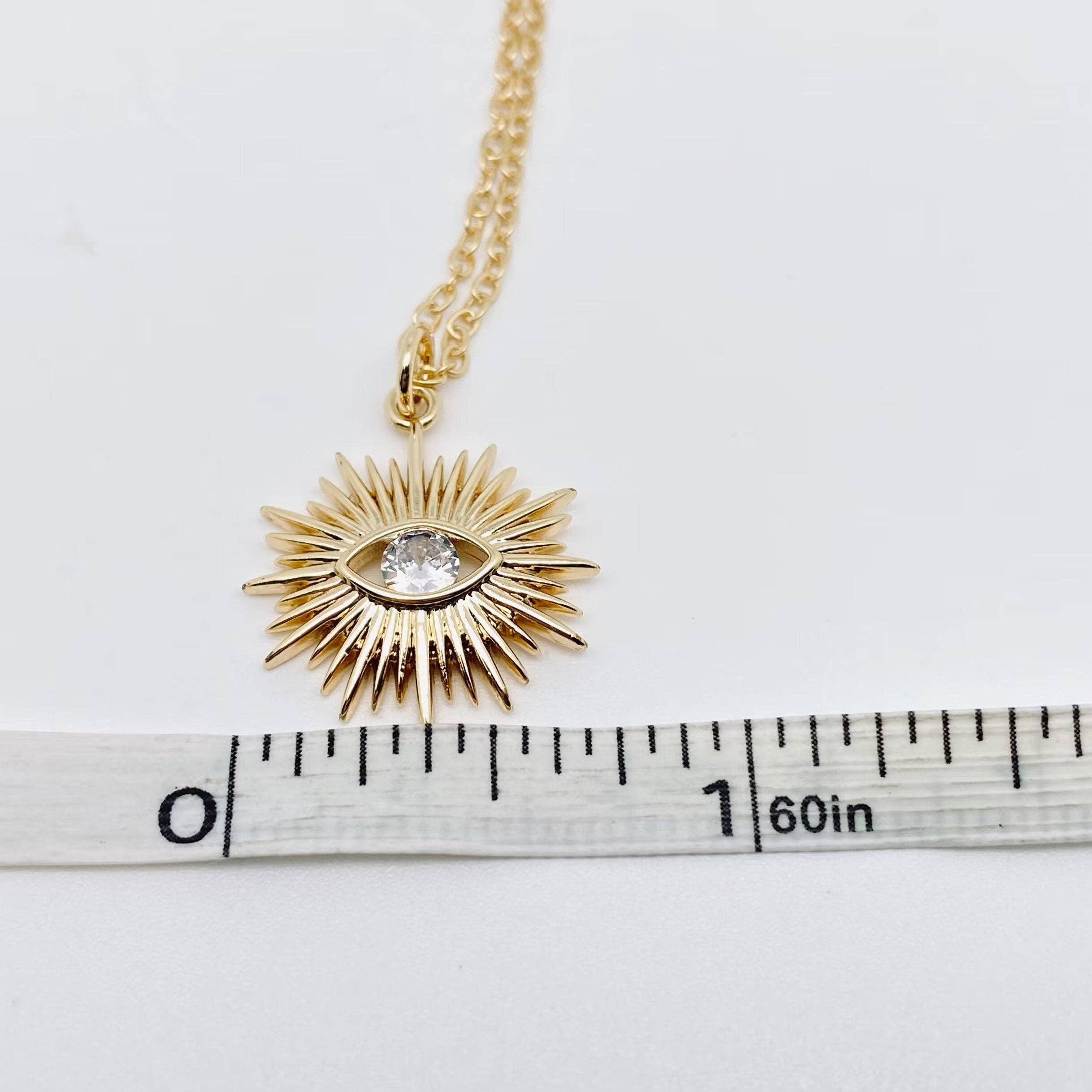 Delicate gold necklace with a cubic zirconia evil eye set in a sunburst design for meaningful everyday style.