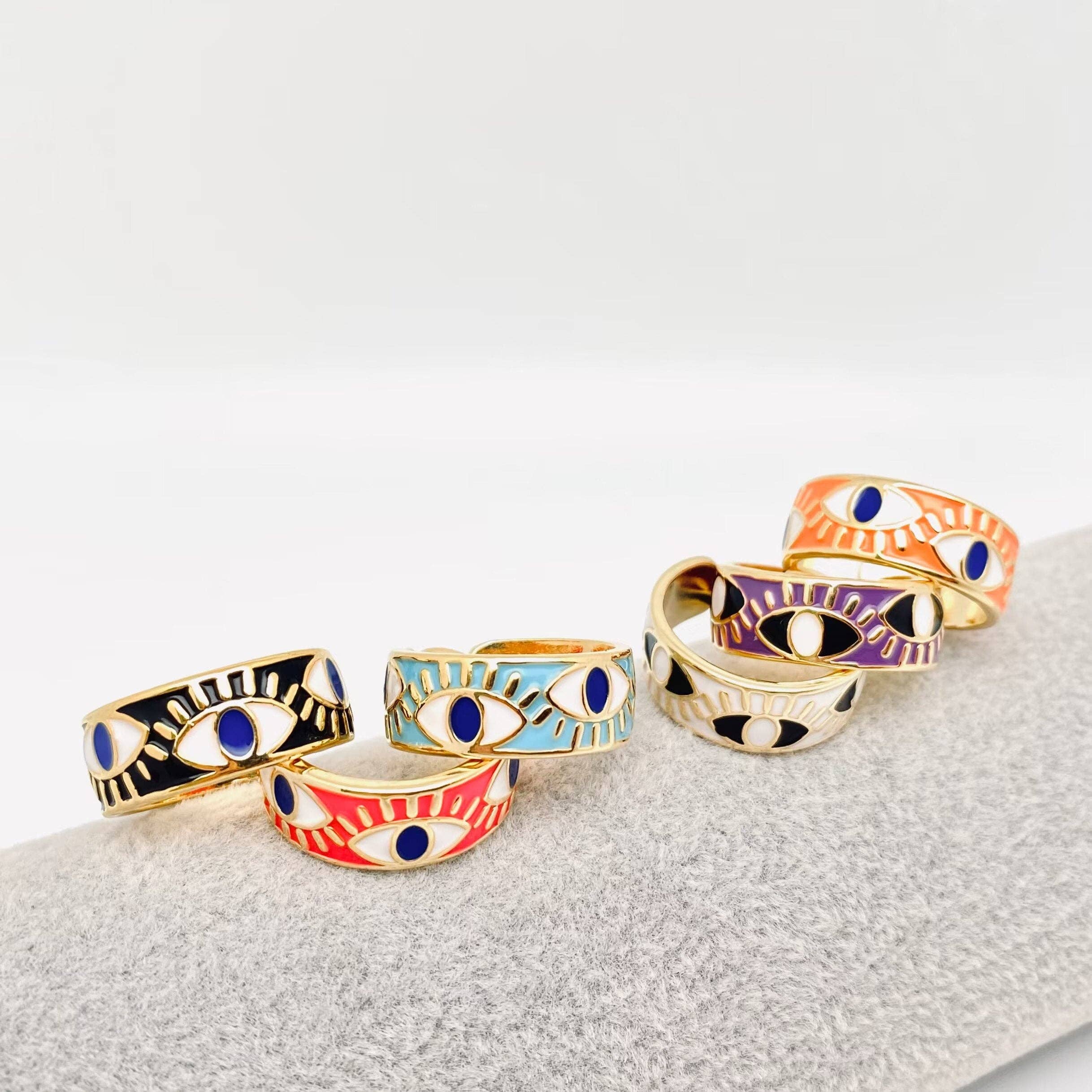 Elegant evil eye ring with white enamel and gold details, designed for style and energy protection