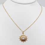 Protective evil eye sunburst pendant necklace for women with a shimmering cubic zirconia in a gold-plated setting.