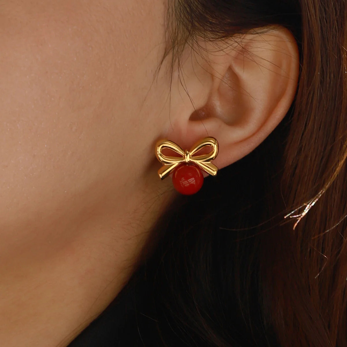 Stylish Cherry Golden Bow Earring featuring a glossy red stone surrounded by a gold bow, 18K gold-plated for a fun, elegant design.