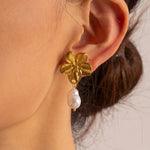 Stunning gold flower earrings with freshwater pearls, offering a feminine touch and perfect for any occasion or daily wear.