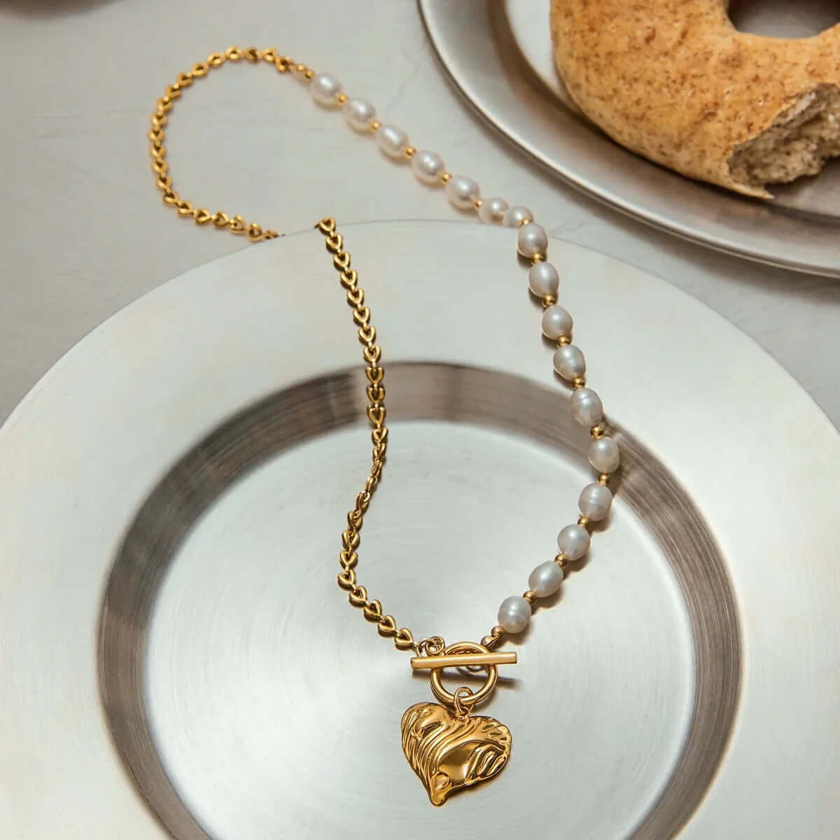 Gold heart pendant necklace featuring a lustrous freshwater pearl, ideal for modern yet timeless everyday wear