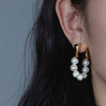 Bold gold hoop earrings with luminous white pearls, perfect for a modern yet timeless statement look