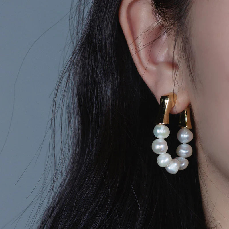 Bold gold hoop earrings with luminous white pearls, perfect for a modern yet timeless statement look