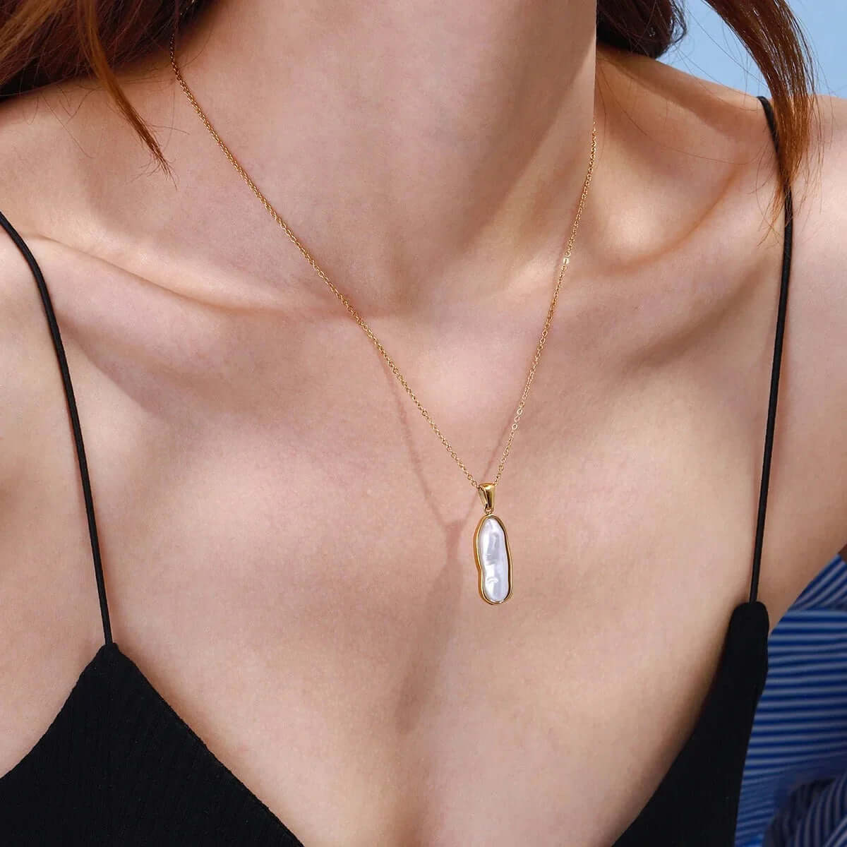 Gold pearl pendant necklace with ocean-inspired charm, featuring a glowing pearl and 18k gold plated chain