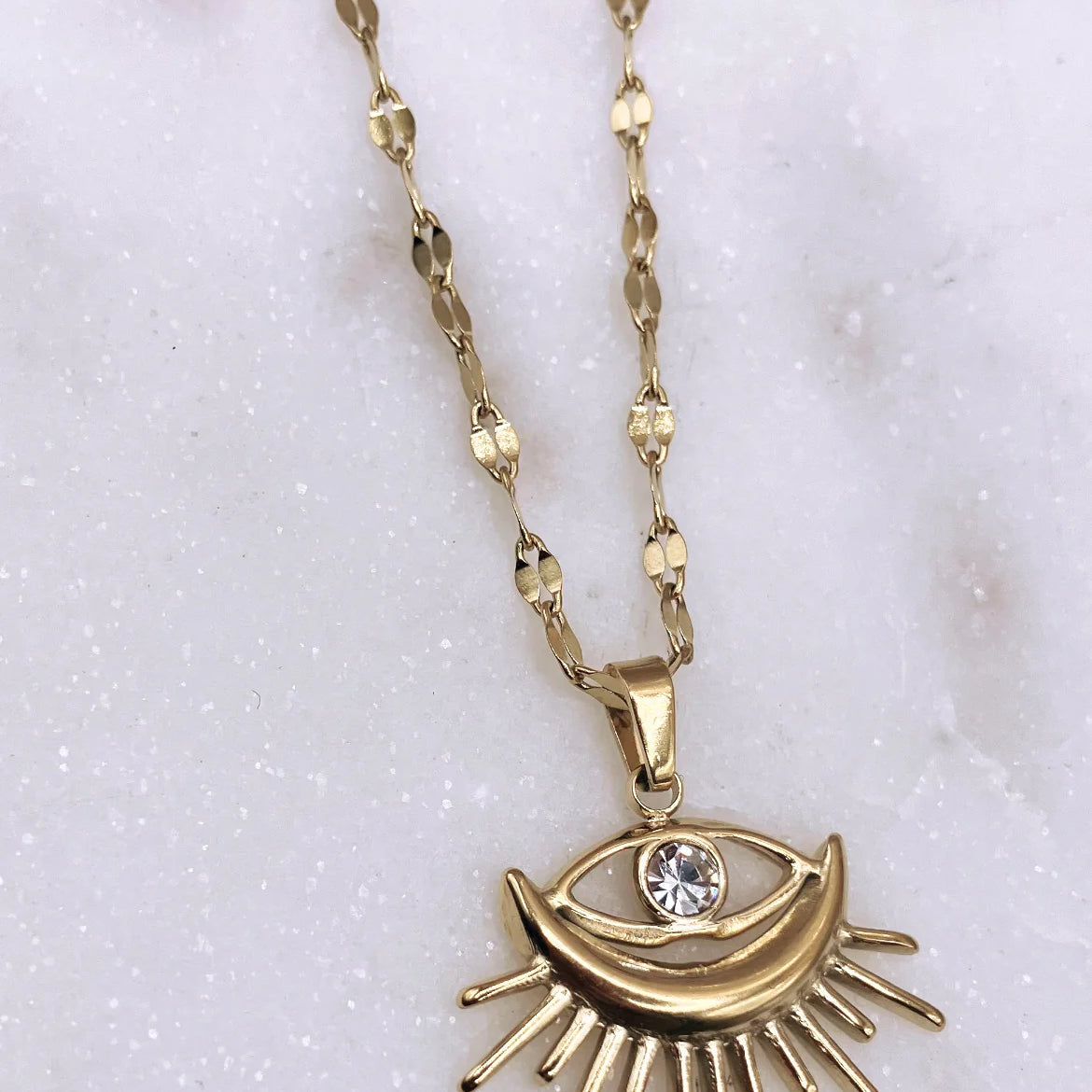 Stylish Gold-Plated Sunburst Evil Eye Pendant Necklace with rhinestone center, perfect for adding charm and protection to any outfit.