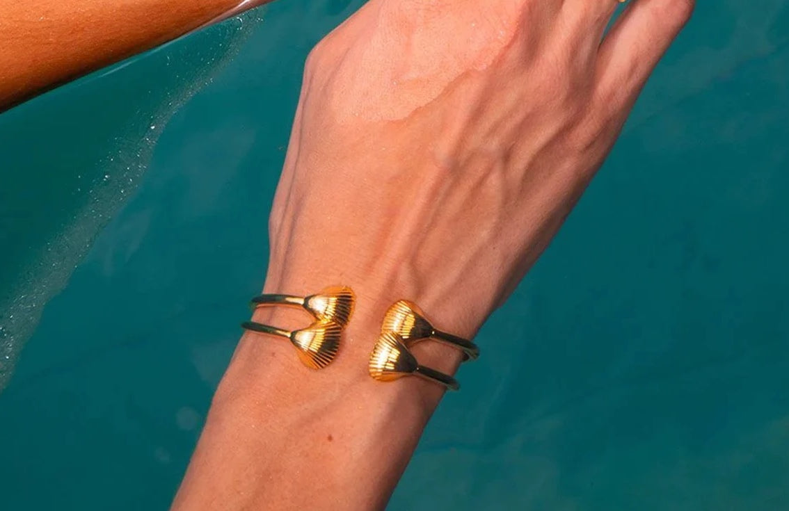 Gold cuff bracelet with two sea shells, 18K gold-plated, perfect for adding a beachy vibe to any outfit.

