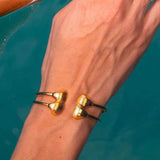 Gold cuff bracelet with two sea shells, 18K gold-plated, perfect for adding a beachy vibe to any outfit.

