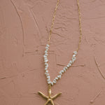 Gold starfish charm necklace with textured finish and shell beads, ideal for ocean lovers and relaxed summer style