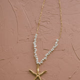 Gold starfish charm necklace with textured finish and shell beads, ideal for ocean lovers and relaxed summer style