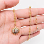 Stylish gold sunburst evil eye necklace with sparkling center stone, perfect for everyday wear and layered looks.