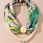 Green floral headband with pearls on a beige background