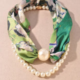 Green floral headband with pearls on a beige background
