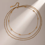 Elegant Layered Gold Necklace with Beads, 18K gold-plated, featuring delicate chains and polished gold beads for a graceful, cascading design.