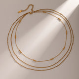 Elegant Layered Gold Necklace with Beads, 18K gold-plated, featuring delicate chains and polished gold beads for a graceful, cascading design.