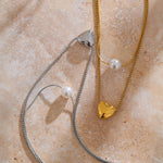 Romantic gold necklace with layered chains, glowing pearl, and heart charm—an elegant and timeless gift idea