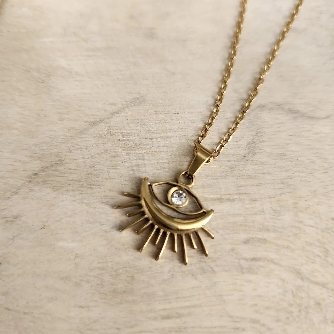 Chic Sunburst Evil Eye Pendant Necklace, gold-plated with a rhinestone center, perfect for protection and adding a stylish touch to any look.