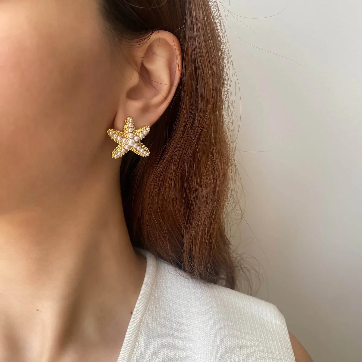 Starfish stud earrings in gold with soft pearl accents, lightweight and perfect for beach lovers or summer-inspired outfits

