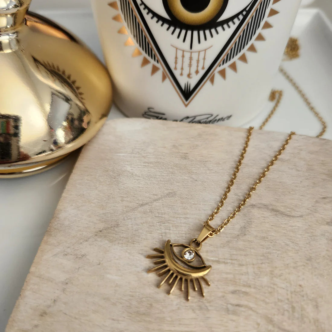 Elegant Sunburst Evil Eye Pendant Necklace, 18K gold-plated with a sparkling rhinestone, combining style and protection for everyday wear.