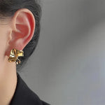 Textured golden flower stud earrings in 18k gold-plated stainless steel, ideal for adding a soft, modern touch to everyday outfits.

