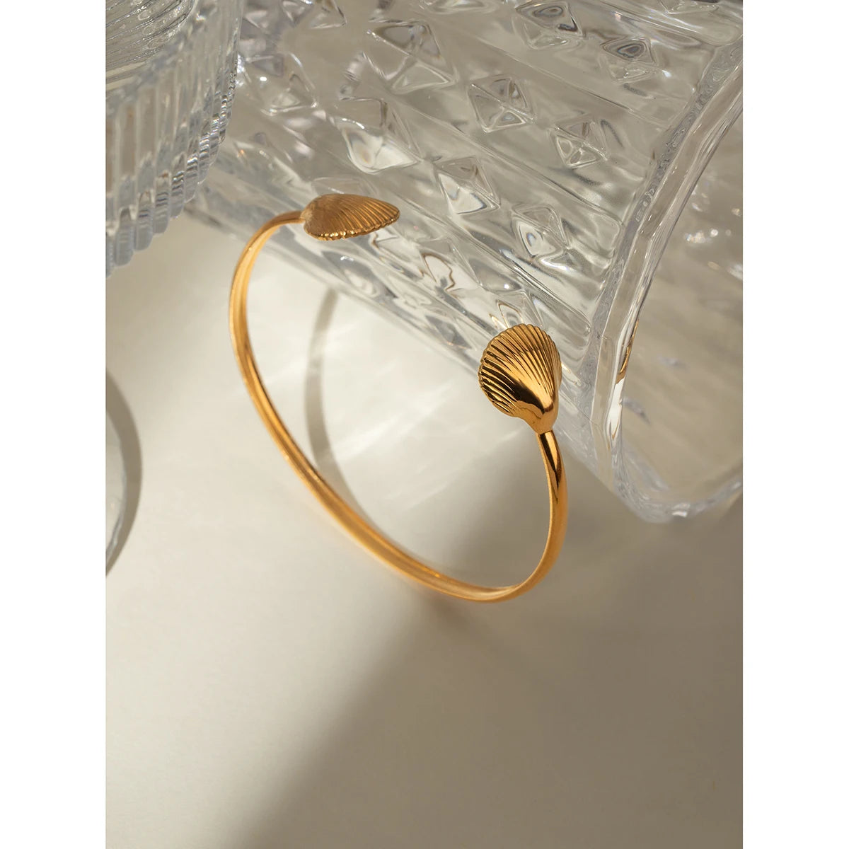 Gold-plated two sea shell cuff bracelet, stylish and lightweight, ideal for a coastal-inspired look.