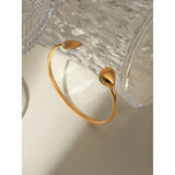 Gold-plated two sea shell cuff bracelet, stylish and lightweight, ideal for a coastal-inspired look.