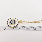 White enamel evil eye necklace featuring a blue stone charm on a gold chain, bringing stylish protection to your everyday look.